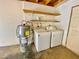 Functional laundry area with washer, dryer, water heater and shelving for convenient storage solutions at 5215 Gray Ln, Las Vegas, NV 89119
