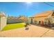 A backyard featuring a mix of stone patio, a small green space, and assorted outdoor furniture and items at 533 Date St, Boulder City, NV 89005
