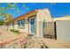 Single story home with a blue front door, multiple windows, and a small gated front yard space at 533 Date St, Boulder City, NV 89005
