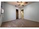 Carpeted bedroom with fan, closet, and view to another room at 5638 Morning Song Cir, North Las Vegas, NV 89031