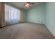 This carpeted bedroom features natural light from the window and soft drapes at 5638 Morning Song Cir, North Las Vegas, NV 89031