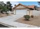 Single-story home features a two-car garage, desert landscaping, terracotta roof, and white painted exterior at 5638 Morning Song Cir, North Las Vegas, NV 89031