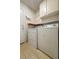 This laundry room features a side-by-side washer and dryer and upper cabinet storage at 5638 Morning Song Cir, North Las Vegas, NV 89031