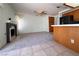 Cozy living room featuring a fireplace and ceiling fan, seamlessly connected to the kitchen area at 5638 Morning Song Cir, North Las Vegas, NV 89031
