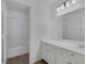 Bright bathroom featuring a single vanity with white cabinets, large mirror and wood look vinyl floors at 5808 Spinnaker Reach Ave, Las Vegas, NV 89130