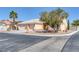 Inviting single-story home features a three-car garage and desert landscaping, complete with mature tree and rock accents at 5808 Spinnaker Reach Ave, Las Vegas, NV 89130
