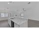 Bright kitchen featuring a large island with marble countertops, stainless steel sink, and modern black appliances at 5808 Spinnaker Reach Ave, Las Vegas, NV 89130