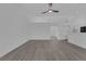 Open living area with fresh white walls, gray wood floors, modern lighting, and open access to other rooms at 5808 Spinnaker Reach Ave, Las Vegas, NV 89130