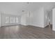 Spacious living area with fresh white walls, gray wood floors, modern lighting, and windows with privacy shutters at 5808 Spinnaker Reach Ave, Las Vegas, NV 89130