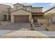 Two-story home with desert landscaping, paver driveway, and covered front porch at 595 Beverly Pine Pl, Henderson, NV 89011