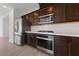 Kitchen featuring stainless steel appliances, dark wood cabinets, and sleek countertops at 595 Beverly Pine Pl, Henderson, NV 89011