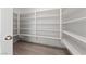 Walk-in pantry features custom white shelving for organized kitchen storage and laminate flooring at 595 Beverly Pine Pl, Henderson, NV 89011