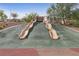 Playground featuring dual slides integrated into a landscaped hill, offering recreational activities at 595 Beverly Pine Pl, Henderson, NV 89011