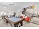 Open-concept game room with a pool table, grand staircase, and access to the dining area at 7141 Groveton Ct, Las Vegas, NV 89131