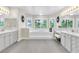 Bright primary bathroom with dual vanities, a large soaking tub, and serene window views for a spa-like experience at 7141 Groveton Ct, Las Vegas, NV 89131