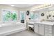 Bright primary bathroom with dual vanities, a large soaking tub, and serene window views for a spa-like experience at 7141 Groveton Ct, Las Vegas, NV 89131