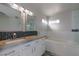 Bright bathroom with dual sinks, marble countertops, a soaking tub, and tiled shower with glass doors at 760 Camino La Paz, Henderson, NV 89012