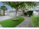 Charming home with a two-car garage, lush landscaping, and brick-lined driveway, creating curb appeal at 760 Camino La Paz, Henderson, NV 89012