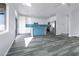 Open-concept kitchen with stainless steel appliances, white cabinets, blue backsplash, and gray wood flooring at 760 Camino La Paz, Henderson, NV 89012