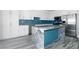 Bright kitchen features white cabinetry, stainless steel appliances, and a marble-top island with blue tile accents at 760 Camino La Paz, Henderson, NV 89012