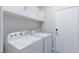 Well-lit laundry room featuring a side-by-side washer and dryer, ample shelving, and a clean, white door at 760 Camino La Paz, Henderson, NV 89012
