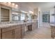 Bathroom with double sinks, granite countertops, and mirrors with wood-look vinyl floors at 7665 Serenity Bay Ln # Lot 58, North Las Vegas, NV 89084