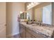 This bathroom offers a double vanity with granite countertops and modern fixtures at 7665 Serenity Bay Ln # Lot 58, North Las Vegas, NV 89084