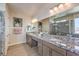 Bathroom featuring double sinks, granite countertop, large mirrors, and a glass-enclosed shower at 7665 Serenity Bay Ln # Lot 58, North Las Vegas, NV 89084