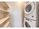 Laundry room featuring modern stacked washer and dryer unit with shelving at 7665 Serenity Bay Ln # Lot 58, North Las Vegas, NV 89084