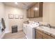Well-organized laundry room with sink, granite counters, cabinetry, washer, dryer, and decor at 7665 Serenity Bay Ln # Lot 58, North Las Vegas, NV 89084