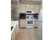 Kitchen with white appliances, light wood cabinets, and stone backsplash at 8101 W Flamingo Rd # 2078, Las Vegas, NV 89147
