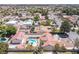Aerial view showcasing a house with a backyard pool, set within a neighborhood of neatly arranged homes and mature trees at 8340 W Fisher Ave, Las Vegas, NV 89149