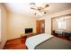 Bedroom with wood floors, ceiling fan, mirrored sliding closet doors, and tv on a shelf at 8340 W Fisher Ave, Las Vegas, NV 89149