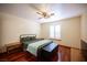 Bedroom with wood floors, ceiling fan, white shuttered window, and a black bed with a blanket chest at 8340 W Fisher Ave, Las Vegas, NV 89149