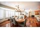 Traditional dining room features wood floors, modern chandelier and bay windows with shutter blinds at 8340 W Fisher Ave, Las Vegas, NV 89149