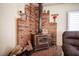 Close up of wood burning stove with brick surround, wooden mantle and brick floor at 8340 W Fisher Ave, Las Vegas, NV 89149