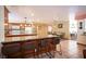 Open kitchen with island bar seating, wood cabinets and adjacent dining room at 8340 W Fisher Ave, Las Vegas, NV 89149