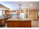 Traditional kitchen with wood cabinets, granite countertops, tile backsplash, and island at 8340 W Fisher Ave, Las Vegas, NV 89149