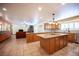 Open kitchen features an island with granite countertops, tile floors, and seamless flow to the living area at 8340 W Fisher Ave, Las Vegas, NV 89149