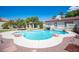 Backyard pool with rock features, mature landscaping and an adjacent shaded outdoor lounge area at 8340 W Fisher Ave, Las Vegas, NV 89149