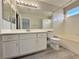 Bathroom with a large mirror, white cabinets, tub-shower combo, and gray wood-look flooring at 8717 Harvest Valley Ave, Las Vegas, NV 89129