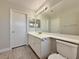 A functional bathroom with wood-look floors, a large vanity, and ample mirror space at 8717 Harvest Valley Ave, Las Vegas, NV 89129