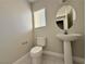 A half bathroom featuring a pedestal sink and tiled floors is well-lit by a window at 8717 Harvest Valley Ave, Las Vegas, NV 89129