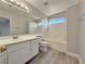 Bright bathroom features a tub with shower, white cabinets, and a spacious mirror at 8717 Harvest Valley Ave, Las Vegas, NV 89129