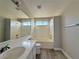 Bathroom with a tub, a vanity, a window, and bright lights, offers a modern, clean aesthetic at 8717 Harvest Valley Ave, Las Vegas, NV 89129