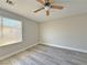 Bright bedroom with wood-look floors and a window is lit with a modern ceiling fan at 8717 Harvest Valley Ave, Las Vegas, NV 89129
