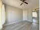 A standard bedroom with wood-look floors, neutral colored walls, a fan, and a large closet at 8717 Harvest Valley Ave, Las Vegas, NV 89129