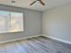 Bright bedroom with wood-look floors and a window is lit with a modern ceiling fan at 8717 Harvest Valley Ave, Las Vegas, NV 89129
