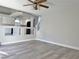 Spacious living area featuring a partial wall to the kitchen and modern gray flooring at 8717 Harvest Valley Ave, Las Vegas, NV 89129