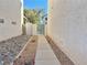 View of a side yard with a stone path and rock landscaping between two buildings at 8717 Harvest Valley Ave, Las Vegas, NV 89129